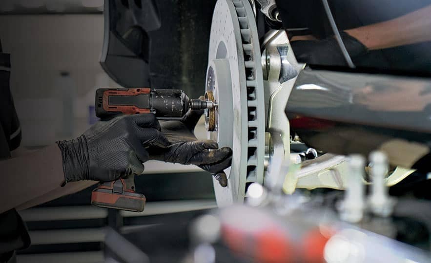 technician screws in new brake pads