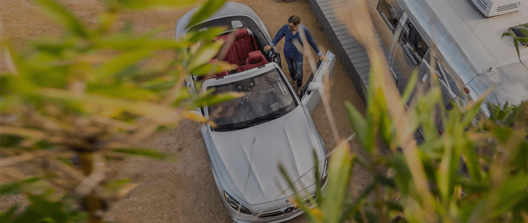 aerial view of man getting into mercedes-benz convertible