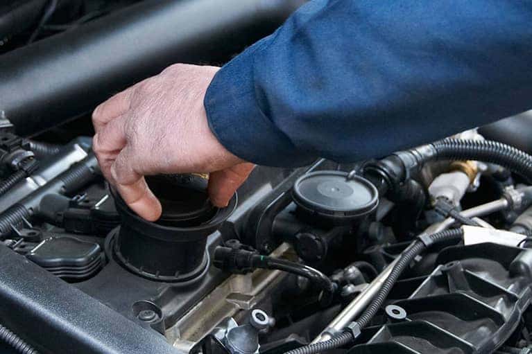 Person checking the oil cap