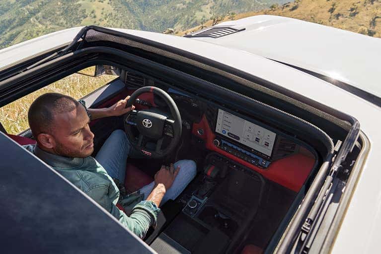 Person using dashboard touch screen with rooftop open