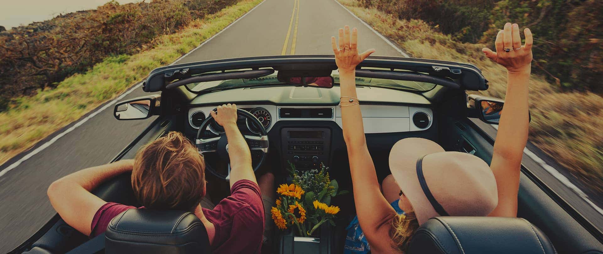 two people driving in a convertible