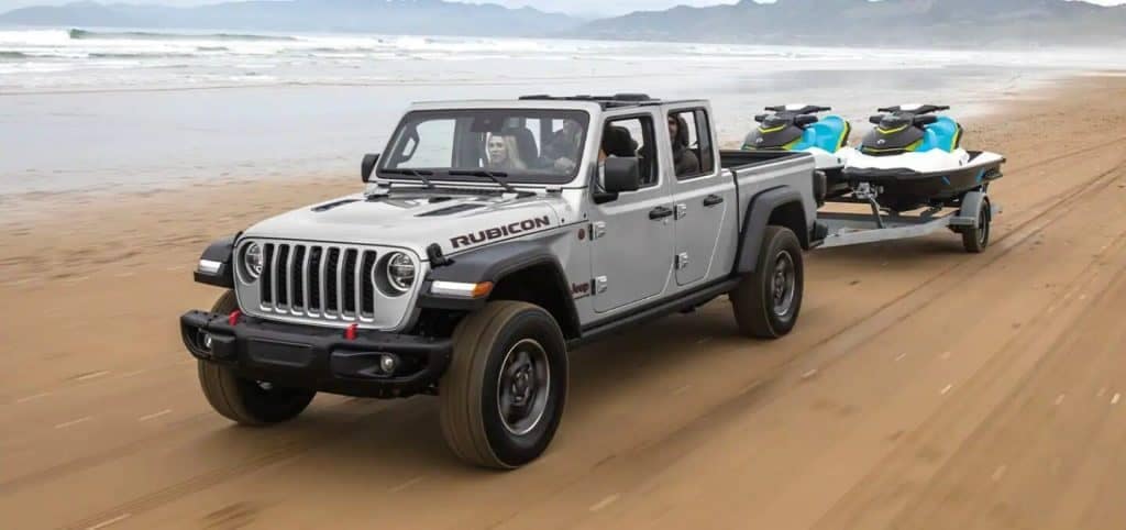 Gray Jeep Gladiator Two Jet Skis on the Beach