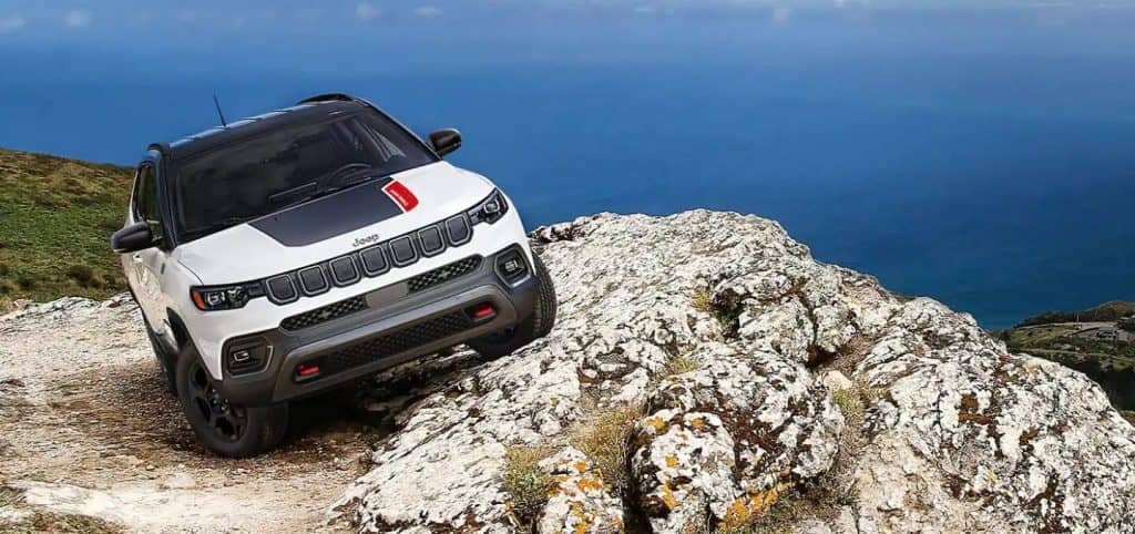 White Jeep Compass SUV Off-Road Ocean Rocks