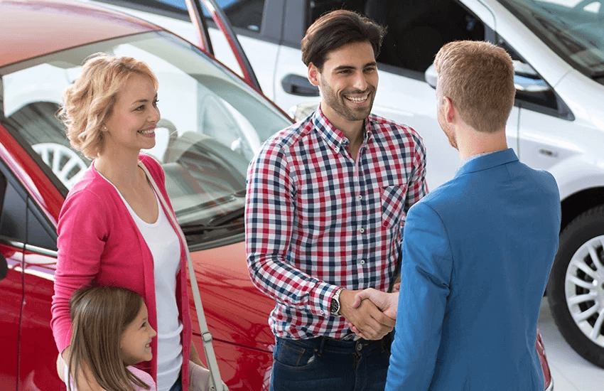 Handshake in front of a car