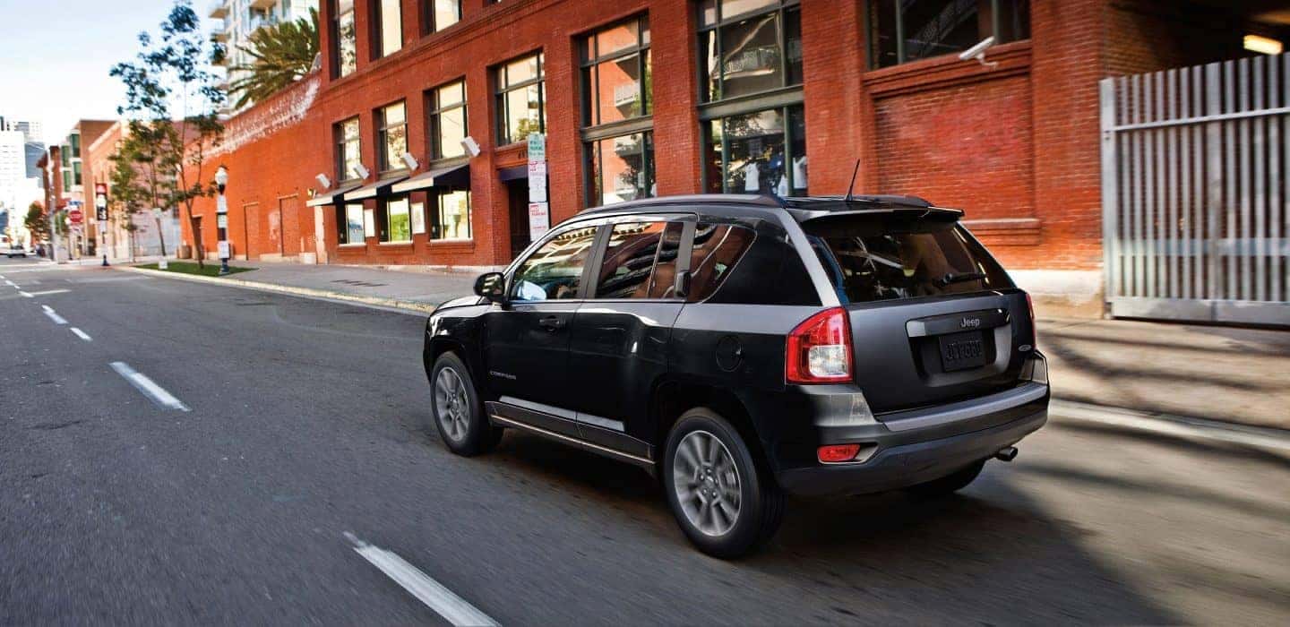 2017 Dark Grey Jeep Compass driving through a small town