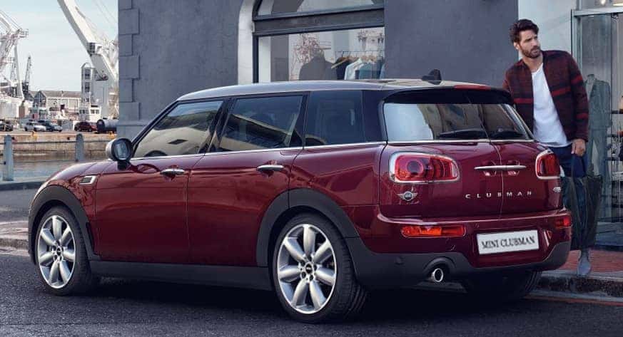 Red MINI parked ons treet with person standing on the right side