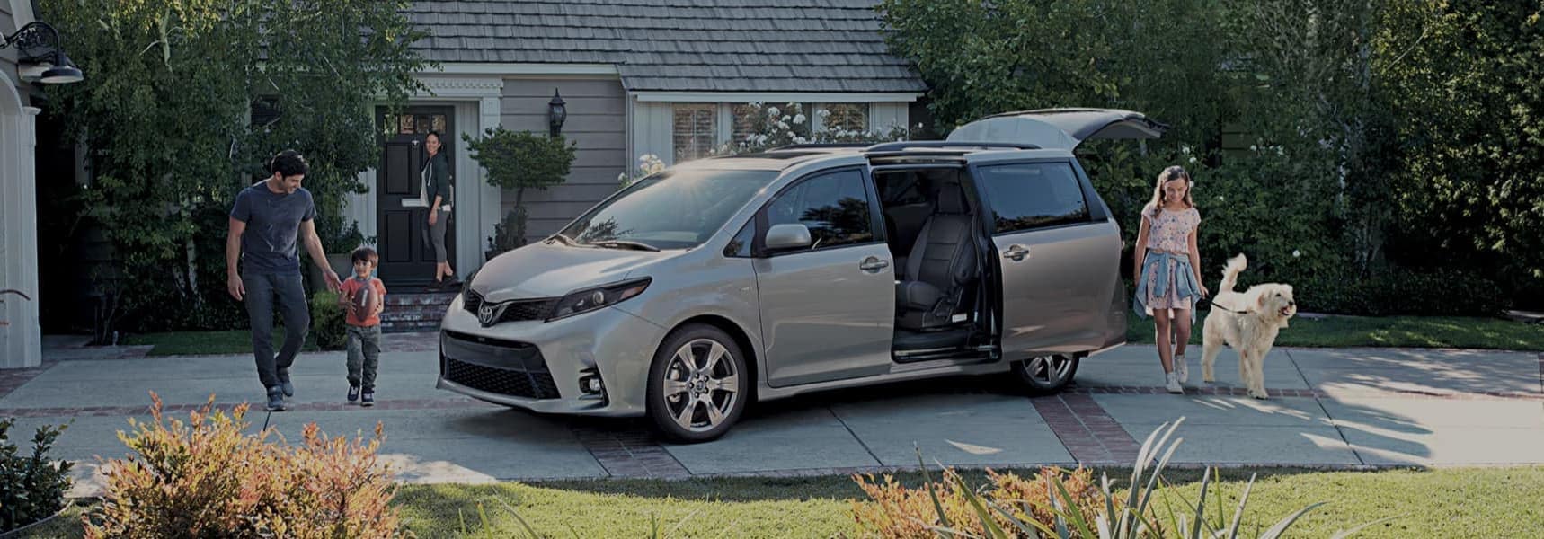 Family in driveway loading up toyota van