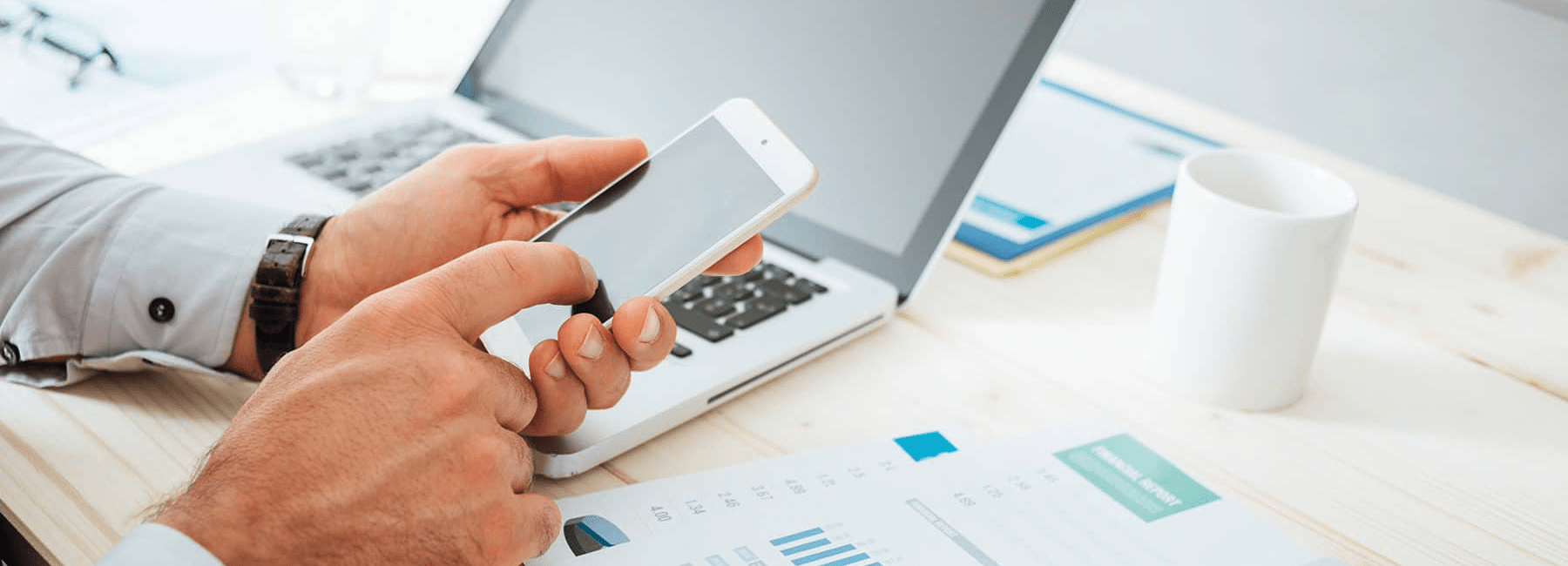 man-using-phone-laptop-to-calculate-finances