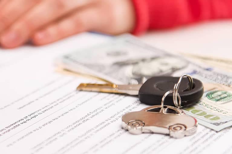 Vehicle keys on top of a finance agreement