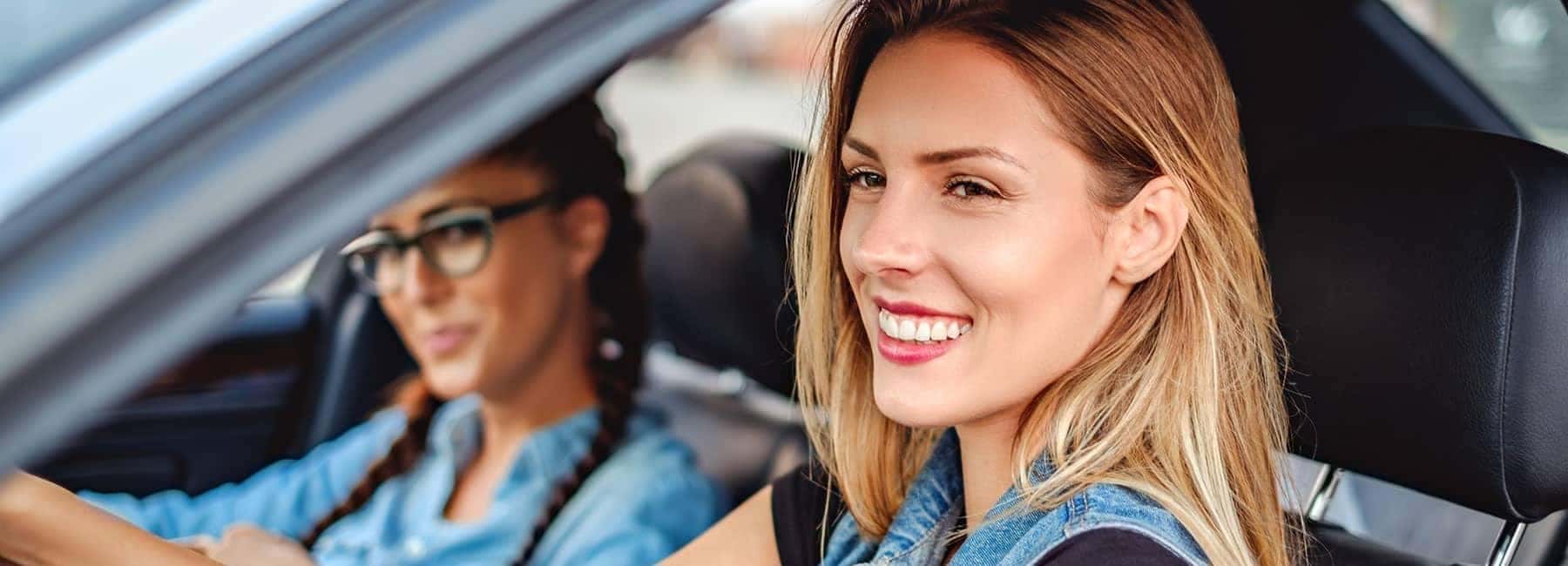 two happy women driving car