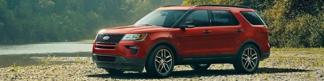 Red Ford Explorer parked at an angle in the wilderness
