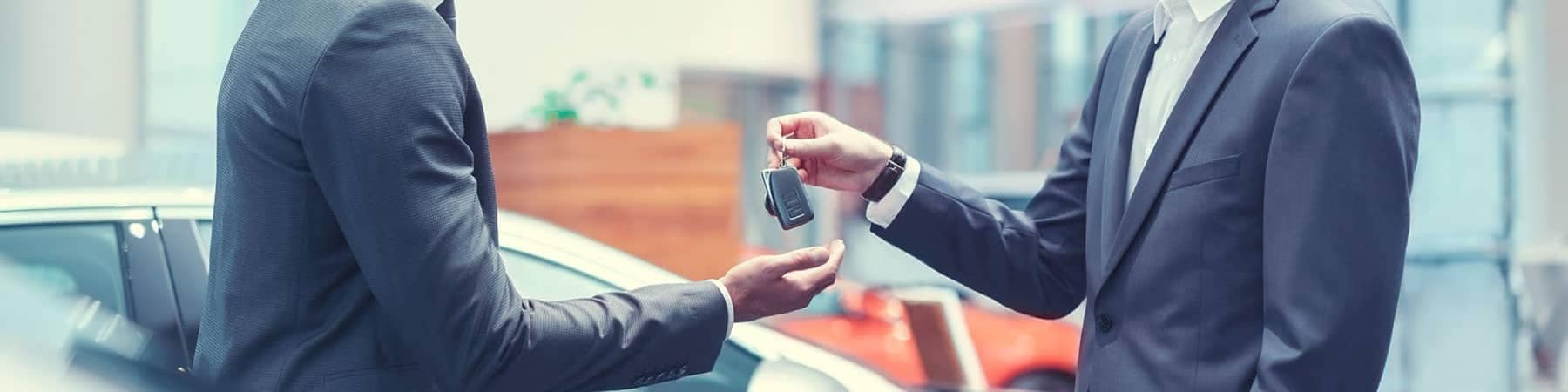 Dealership Salesman Handing Keys Over to Man