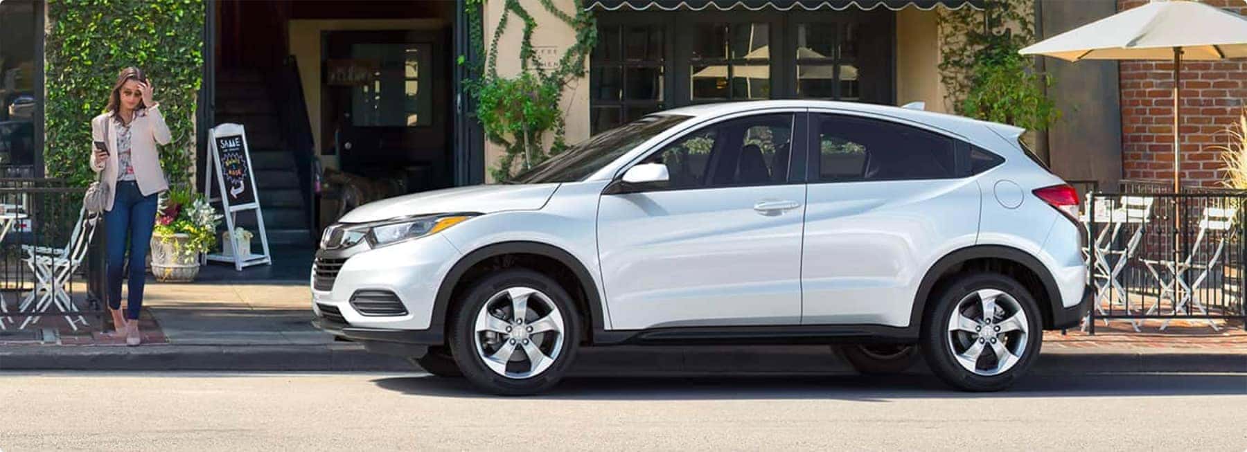 Woman walking out to her white Honda SUV