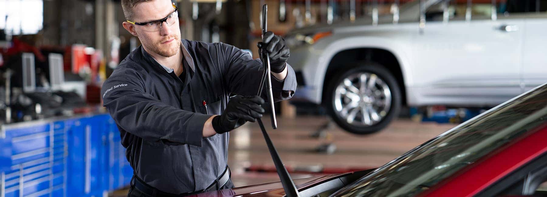GM service technician examining a wiper blade