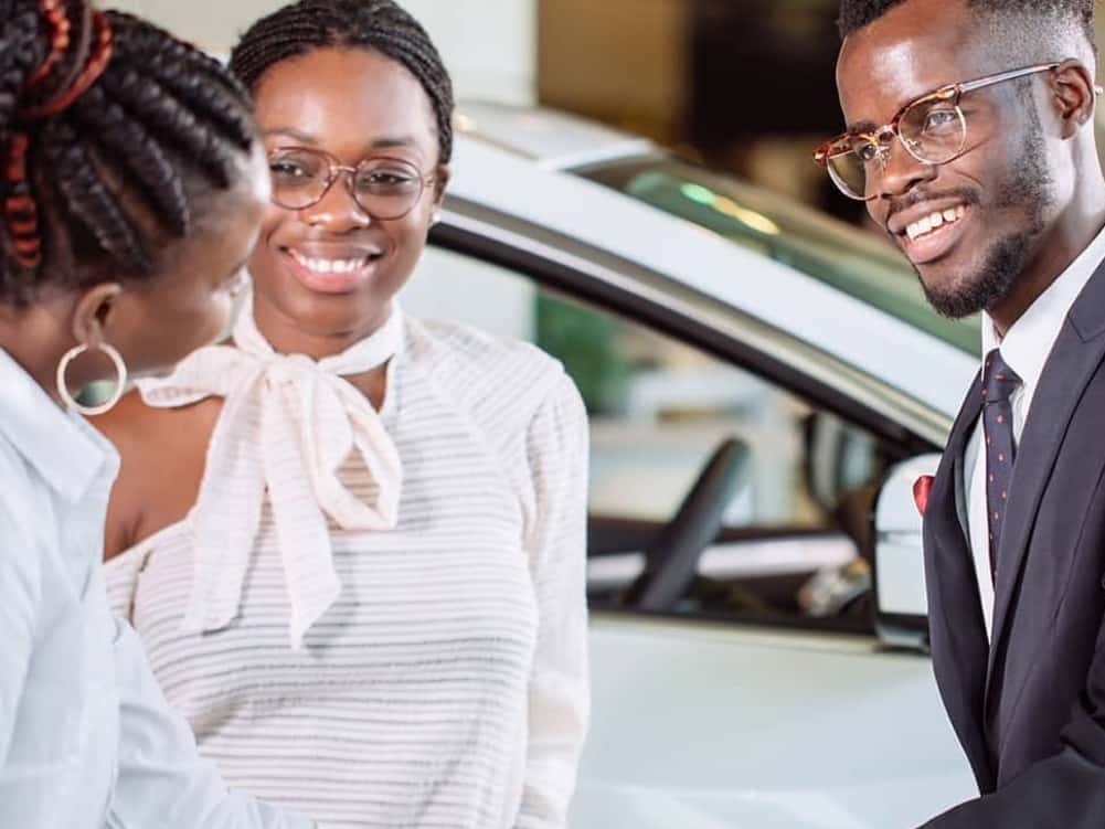 man is shaking hands with saleswoman and smiling