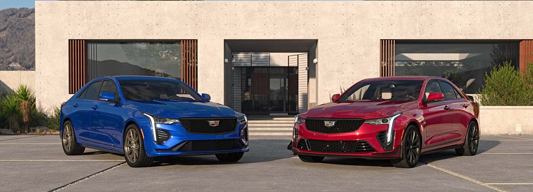 Two 2022 Cadillac CT4-V parked in front of a desert home