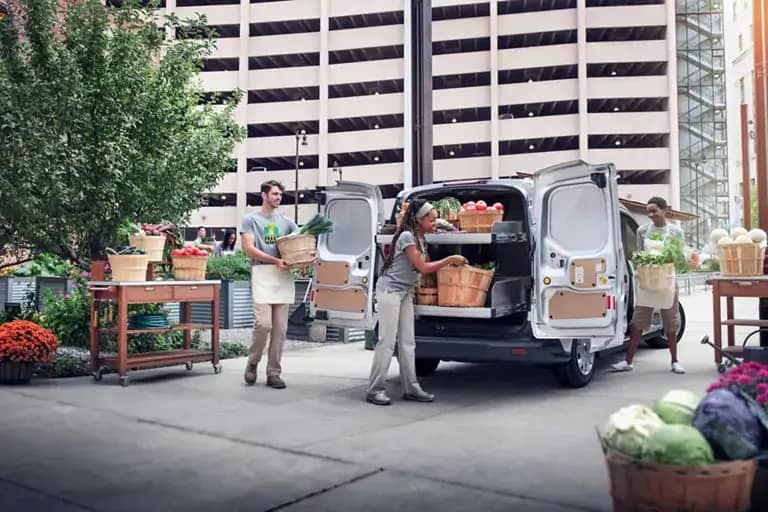 2021 Ford Transit Connect with man and woman unloading farmer's market supplies out the back