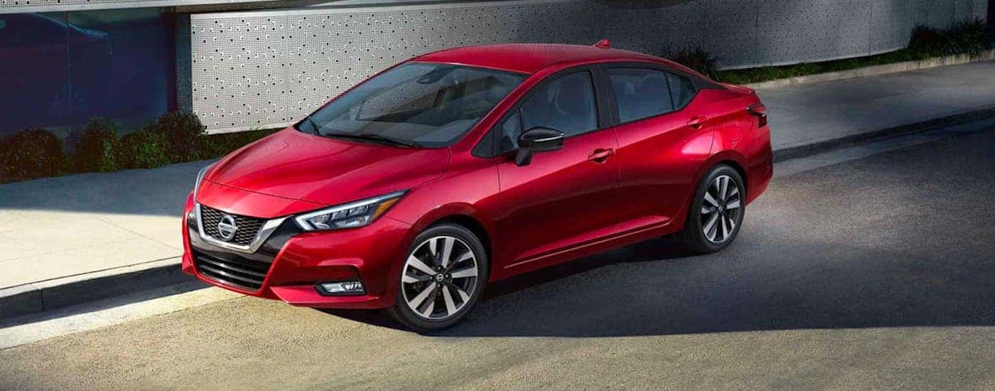 A red 2021 Nissan Versa is parked on a street.
