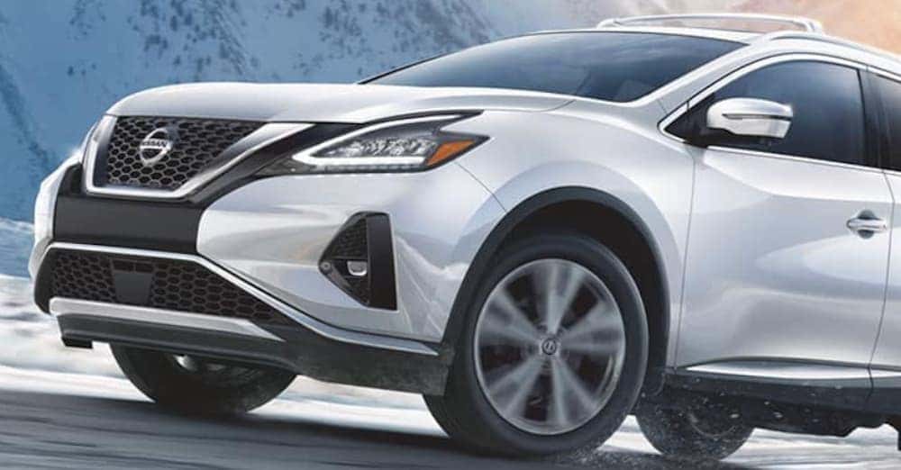A white 2020 Nissan Murano is driving on a snowy road.