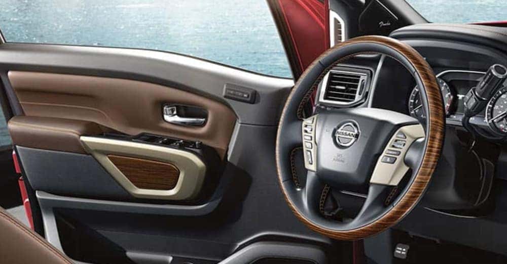 The open door and steering wheel are shown in a 2020 Nissan Titan.
