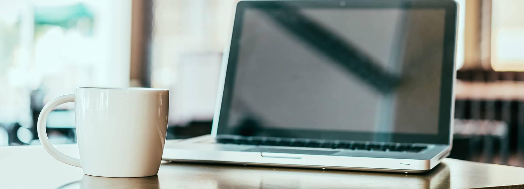 coffee cup and laptop on table