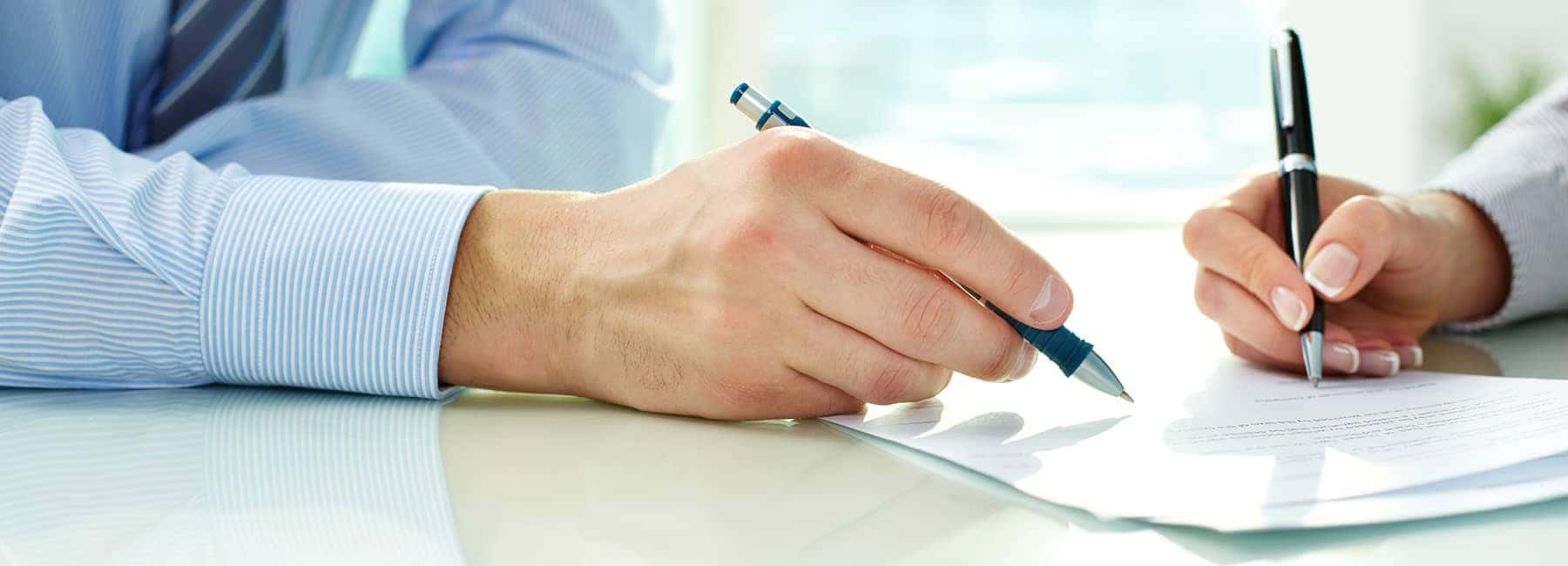 customer-filling-out-paperwork-at-a-car-dealership