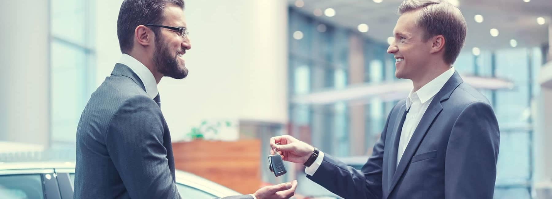 Dealership Salesman Handing car Keys Over to Man