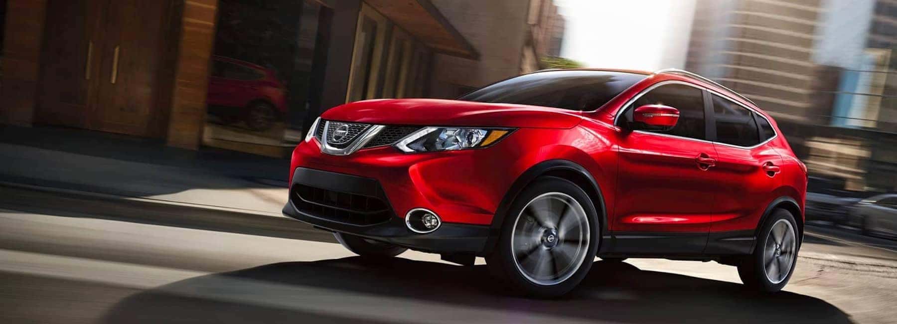 Red Nissan Rogue in the city