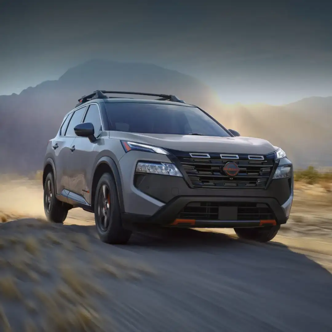 An exterior view of a Nissan Rogue driving down the street