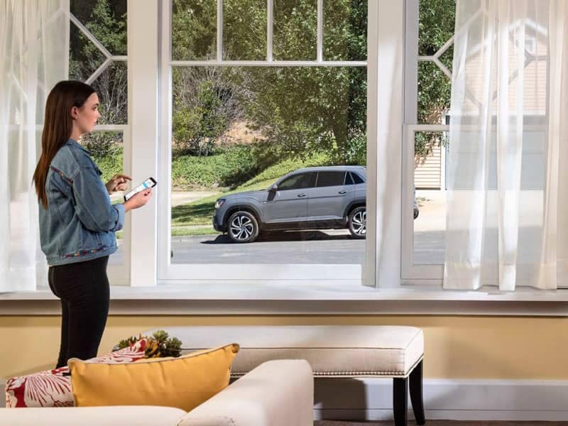 Woman standing in front of window using VW Car-Net