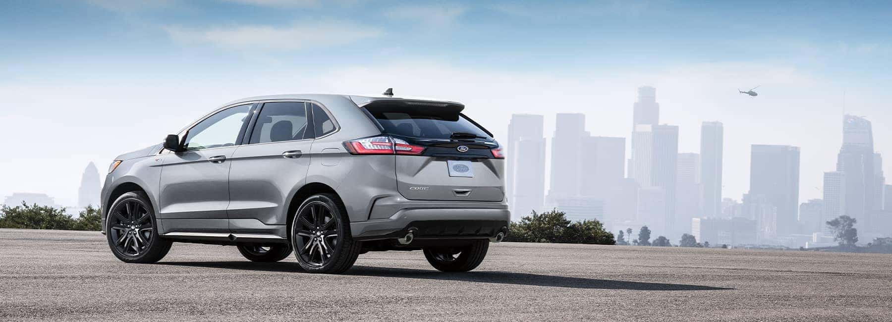 A silver 2021 Ford Edge parked with a cityscape in the background