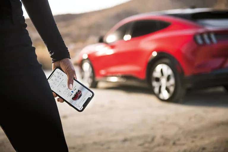 Ford-2022-Mustang-Mach-E-with-man-holding-mobile-phone