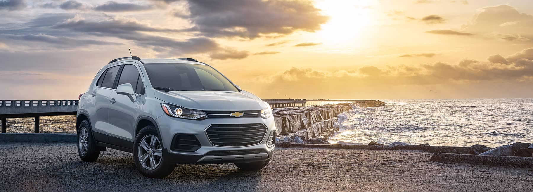 White 2021 Chevrolet Trax parked in front of an ocean pier