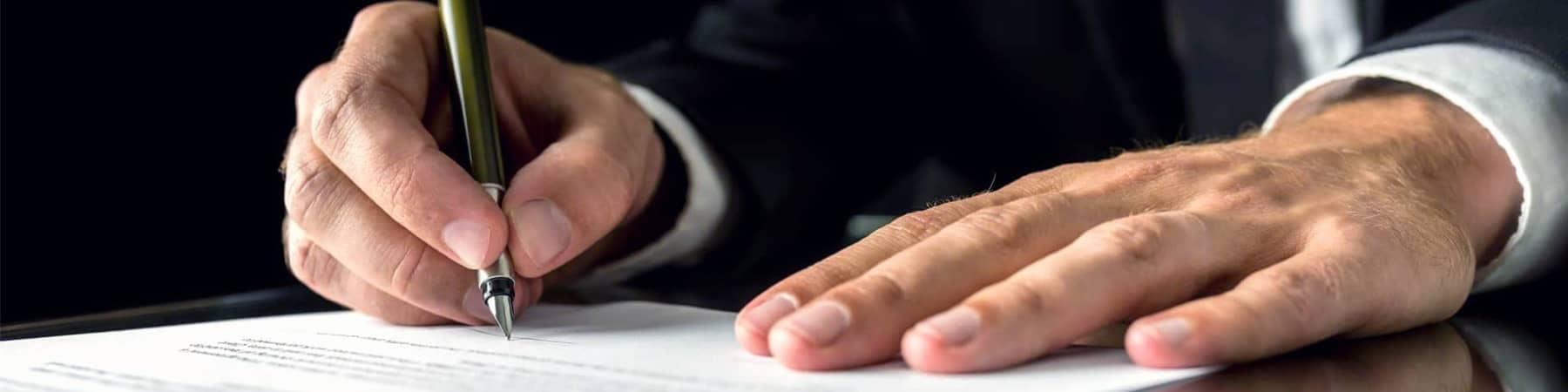 Hands of Man in Suit Signing Document