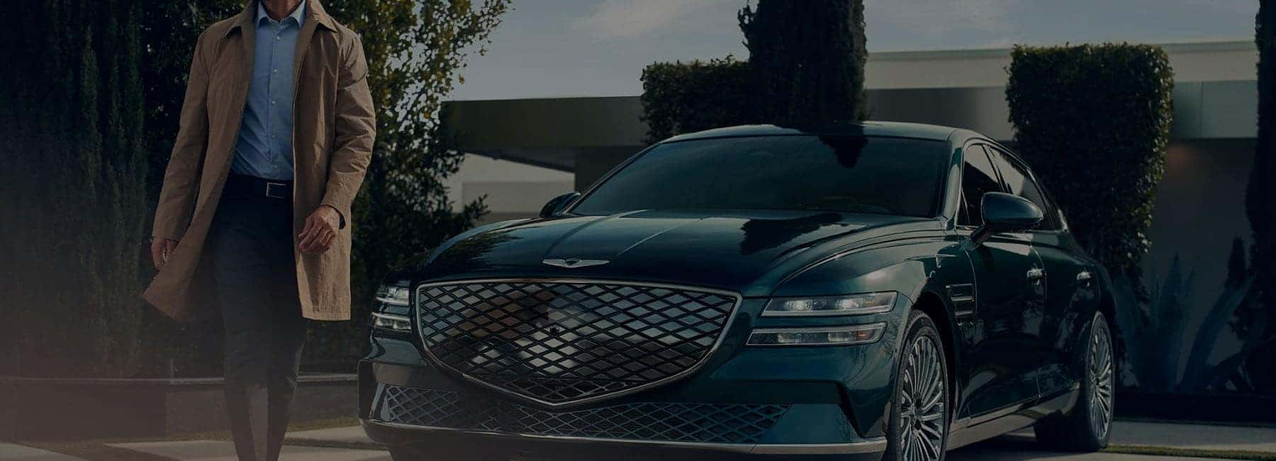 Man walking in front of a Genesis car