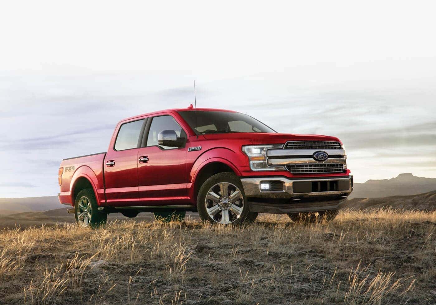 red Ford F-150 parked in grassy plaiin