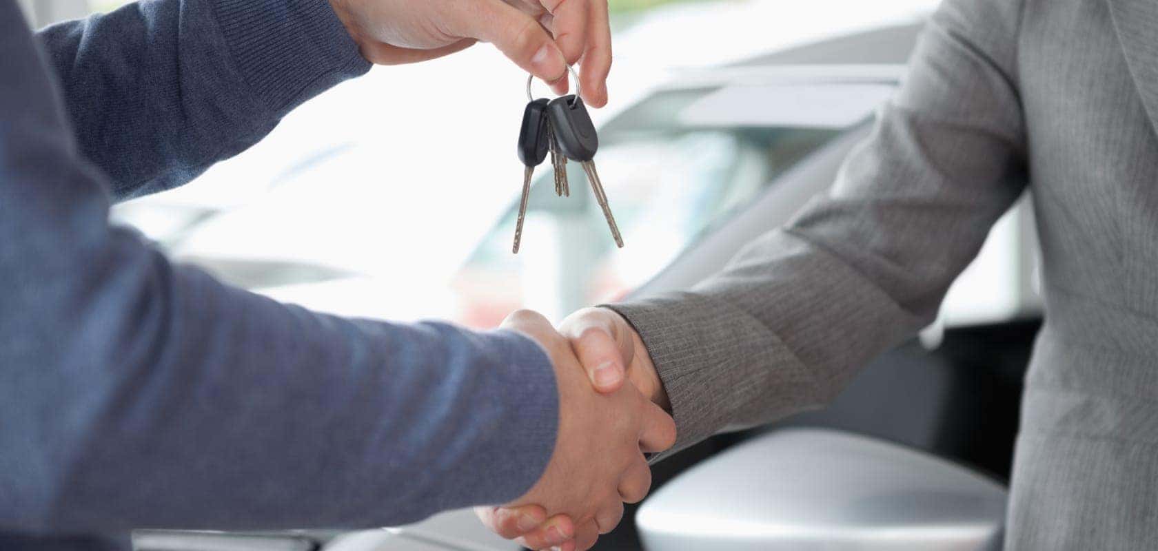 Dealer shaking customer's hand and giving keys