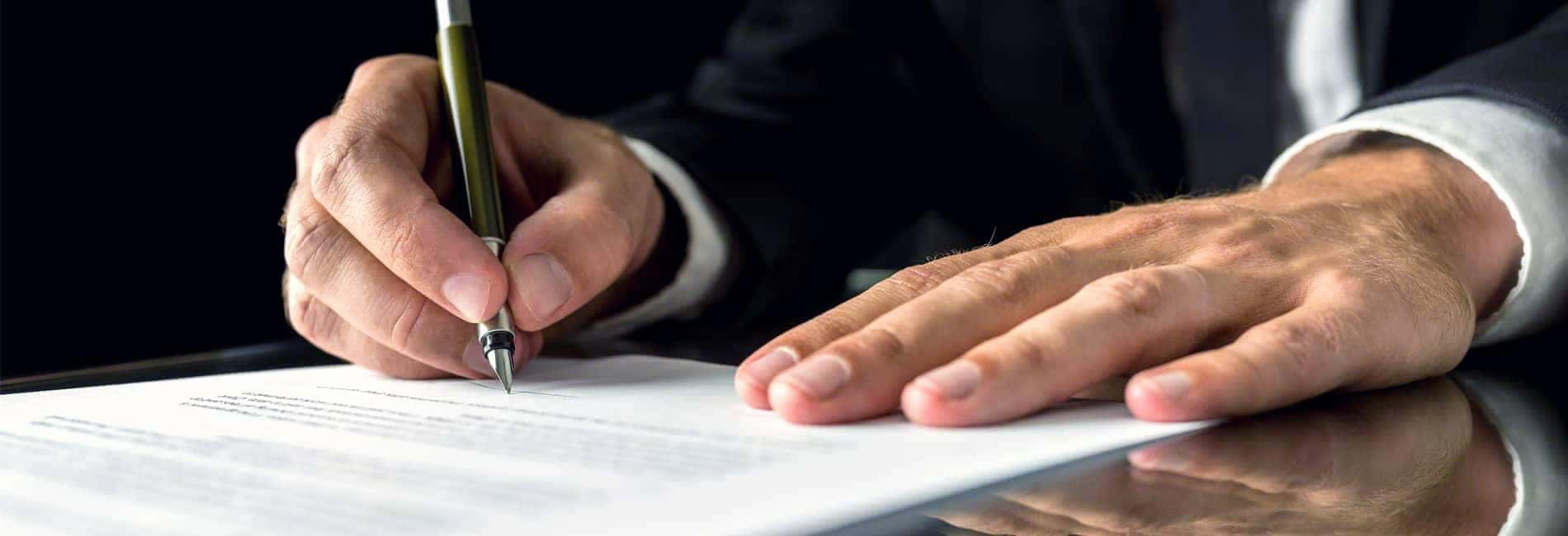 Hands of Man in Suit Signing Document