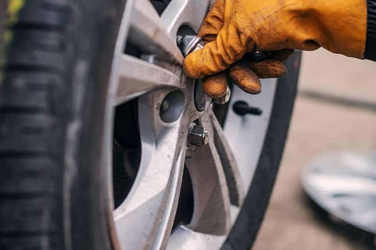 Mechanic replacing the lugnuts on a tire