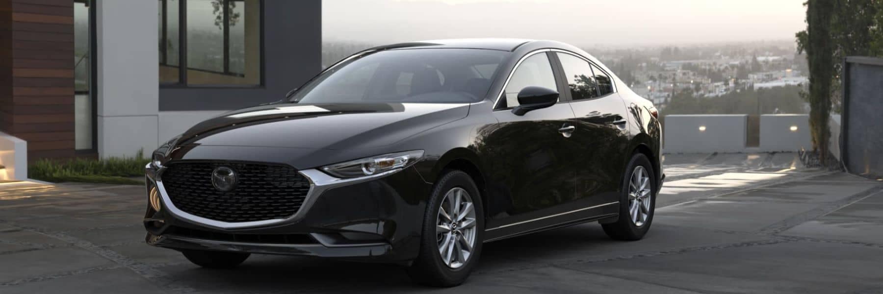 2022-mazda3-sedan-front-3qview-parked-house-driveway-cityview-black