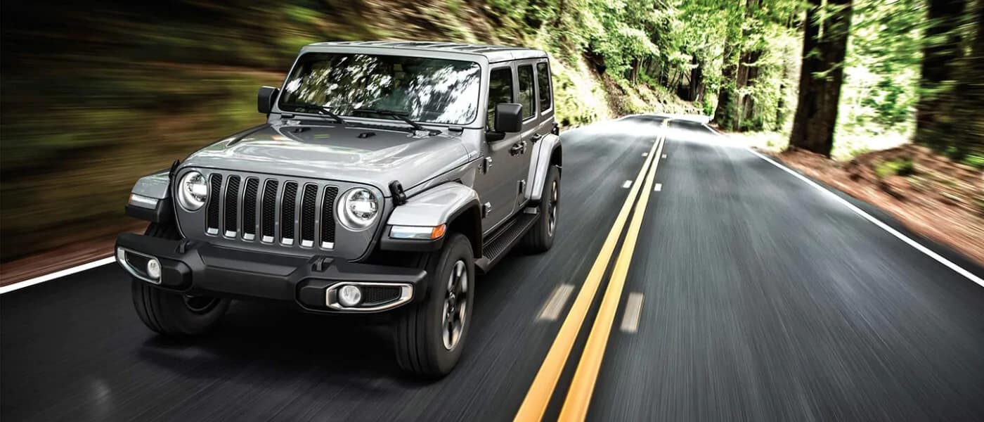 2019 Jeep Wrangler Driving on a road next to the forest