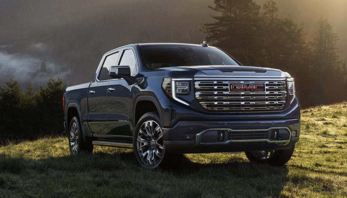 A blue 2024 GMC Sierra 1500 parked off-road.