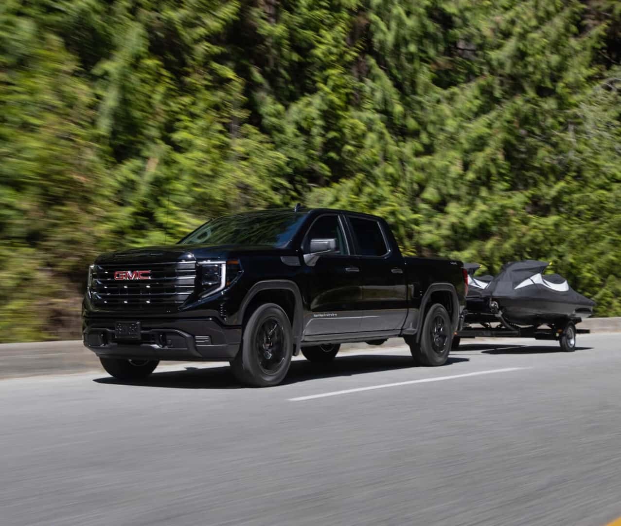 A black 2024 GMC Sierra 1500 towing two jet ski's.