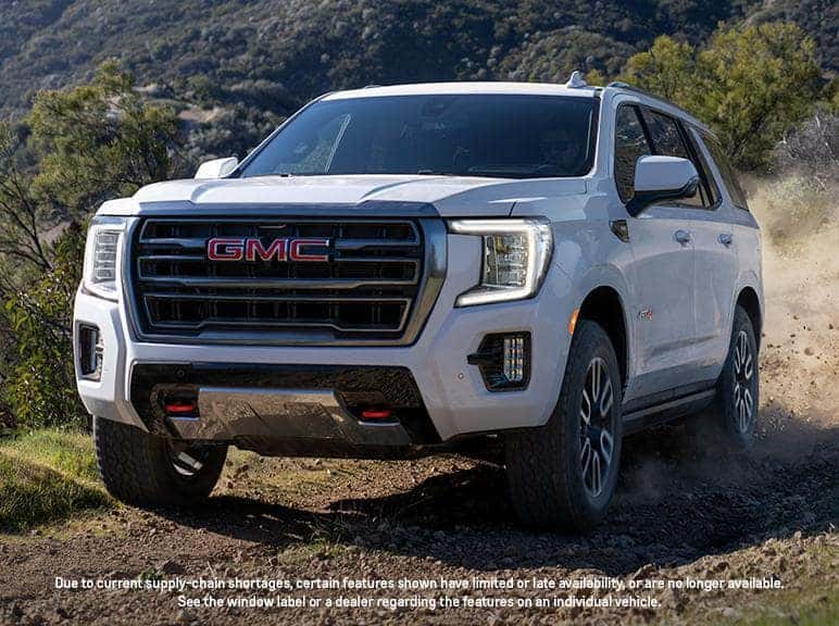 A white 2024 GMC Yukon driving off-road.