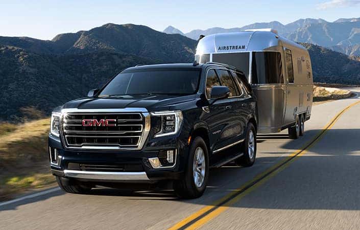 A black 2022 GMC Yukon towing a trailer.