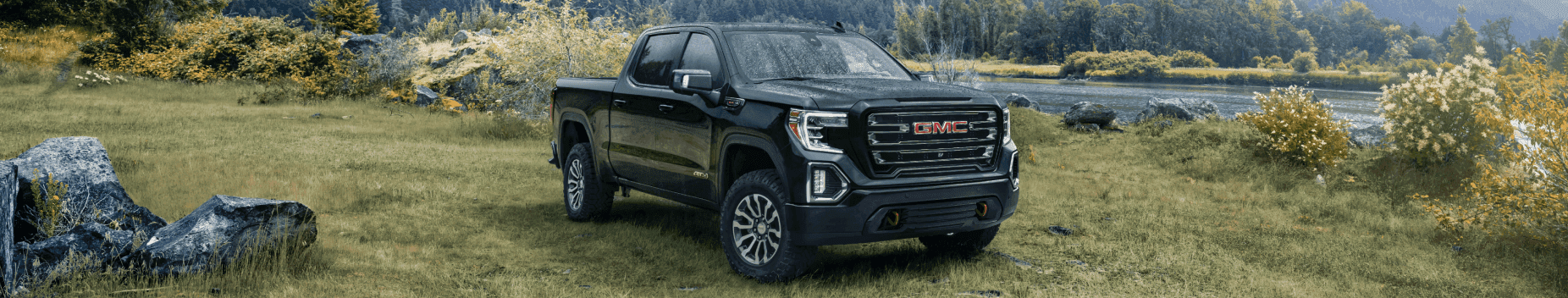 A black GMC Sierra 1500 parked off-road.