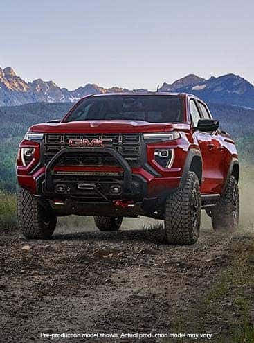 A red 2024 GMC Canyon driving off-road.
