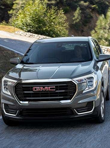 A silver 2023 GMC Terrain driving on a highway.