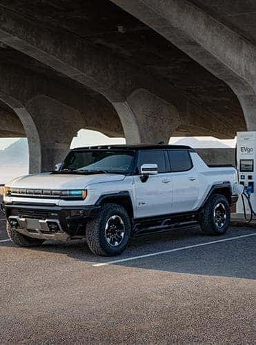A white 2023 GMC Hummer EV charging.