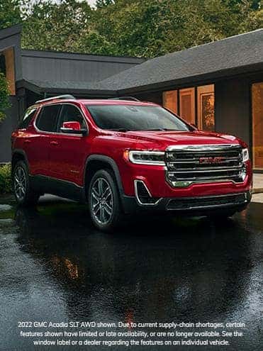 A red 2022 GMC Acadia parked on a driveway.